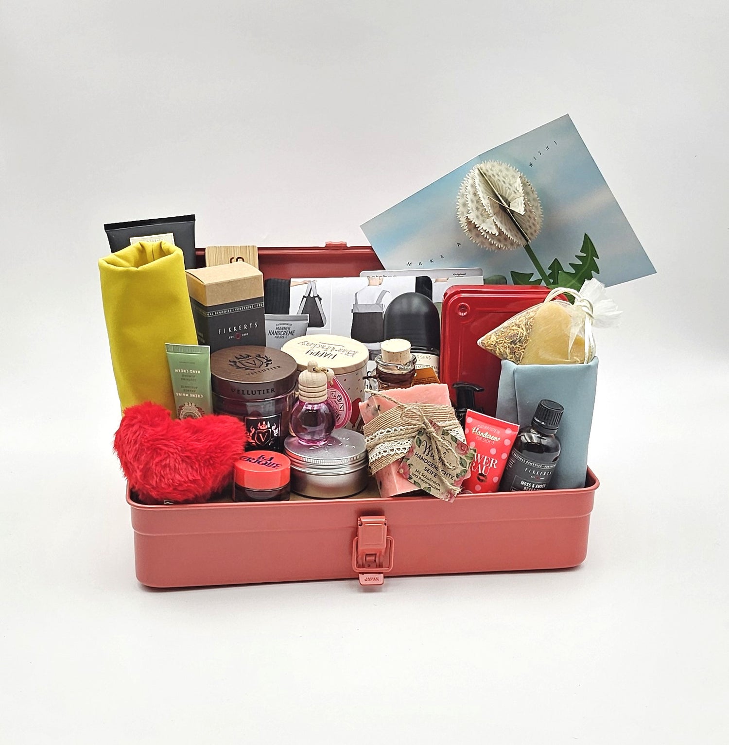 Eine Rosa Geschenkbox gefüllt mit verschiedenen Produkten und Grusskarten