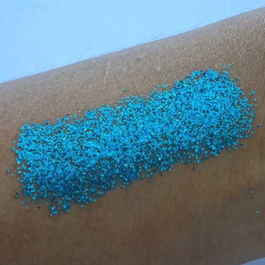 Blauer Glitzer auf der Haut – kühler, leuchtender Schimmer mit auffälligem Funkeln.