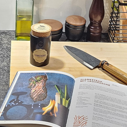 Chimichurri Gewürz in der Küche mit einem offenen Rezeptbuch im Vordergrund