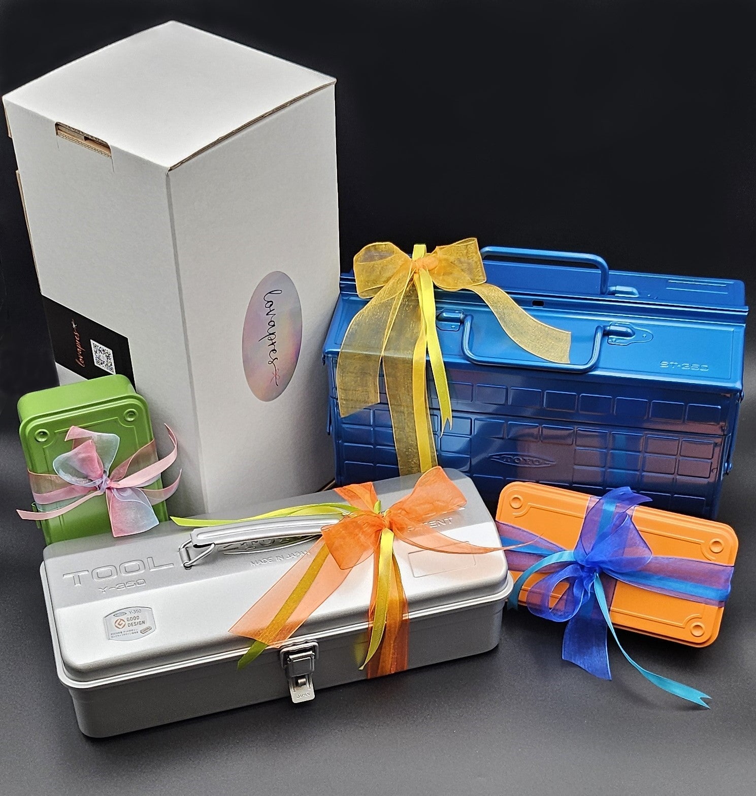 Geschenkboxen in Blau, Orange, Grün und Silber mit bunten Schleifen auf schwarzem Hintergrund