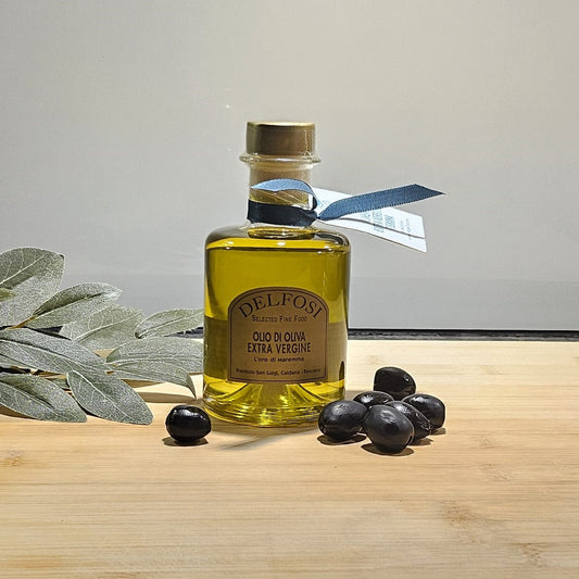 Olivenöl in der Küche mit schwarzen Oliven im Vordergrund