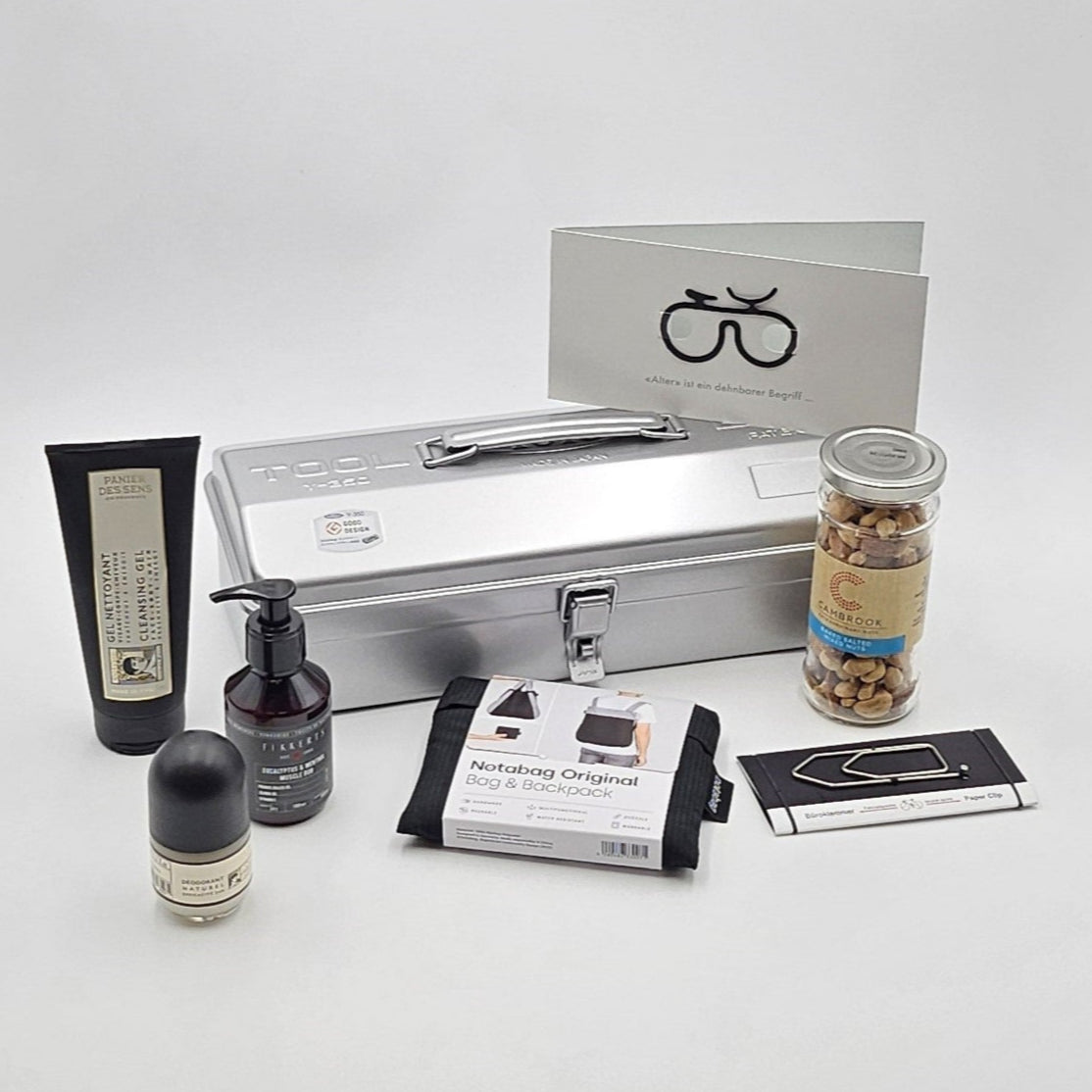 Ride & Recover silberne Geschenkbox, umgeben von den enthaltenen Produkten