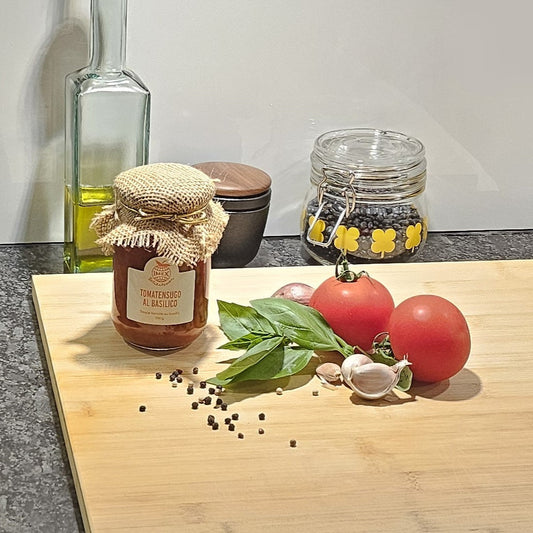 Tomatensauce in der Küche mit Tomaten und Basilikumblätter im Vordergrund