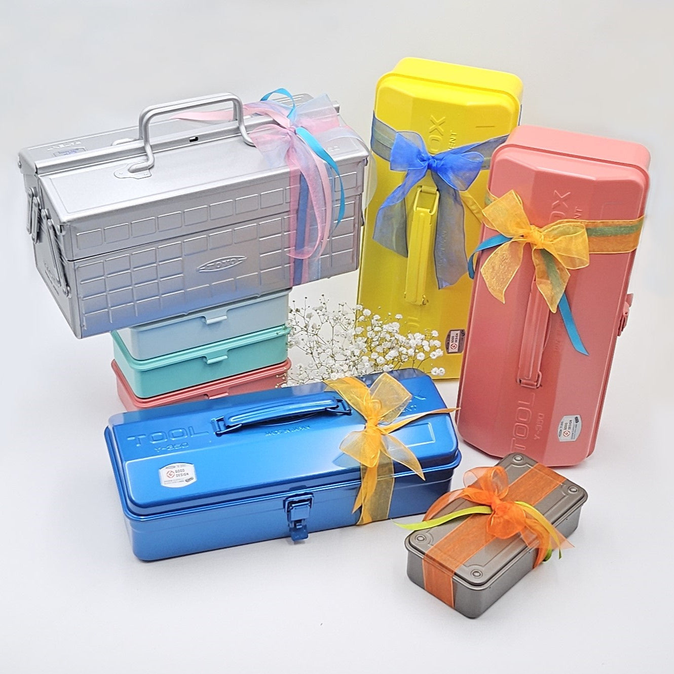 Geschenkboxen in Pink, Gelb, Blau, Braun und Silber mit bunten Schleifen auf weissem Hintergrund