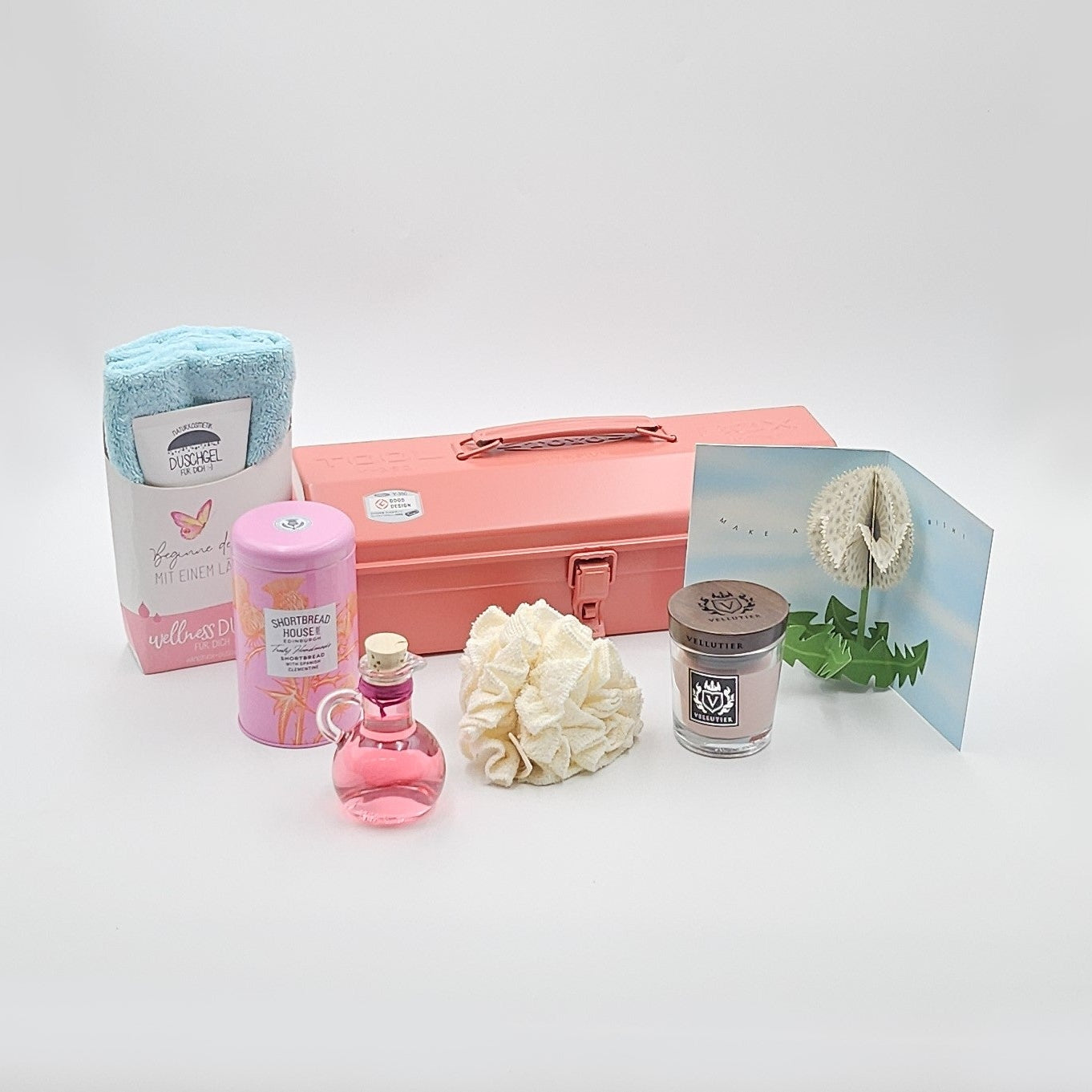 Wohlfühlzeit coralfarbene Geschenkbox, umgeben von den enthaltenen Produkten