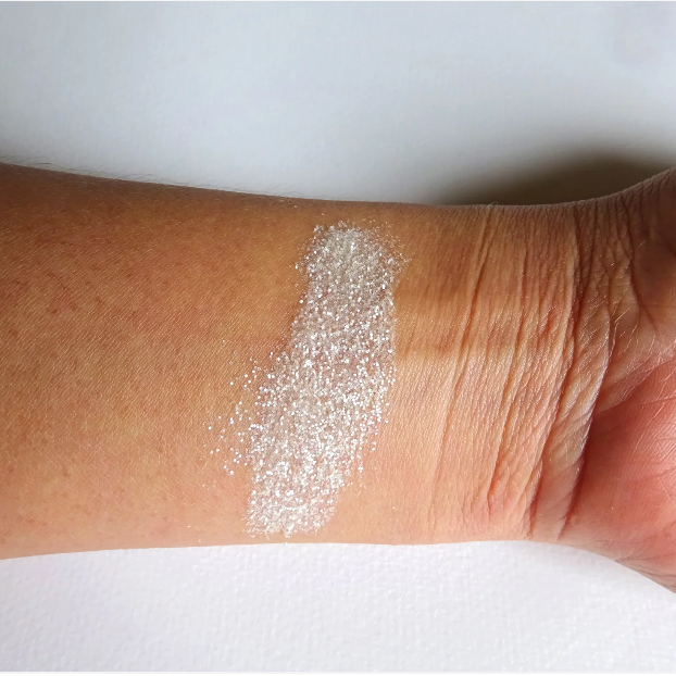 Frostfarbener Glitzer auf der Haut – eisiger, perlmuttartiger Schimmer mit zartem Glow.
