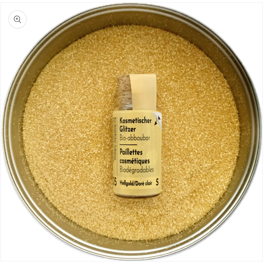 Glitzer Hellgold in Korkflasche umgeben mit Glitzer Partikeln