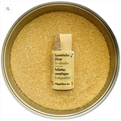Glitzer Hellgold in Korkflasche umgeben mit Glitzer Partikeln