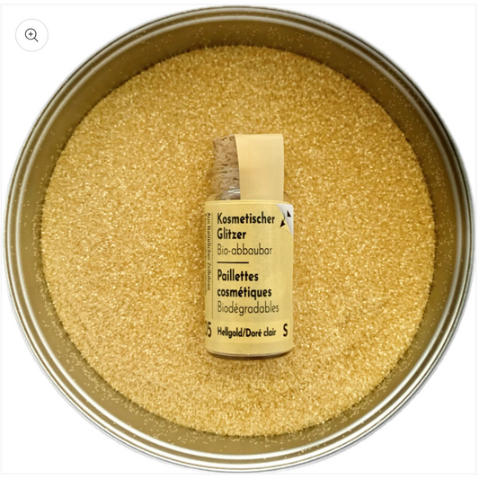 Glitzer Hellgold in Korkflasche umgeben mit Glitzer Partikeln