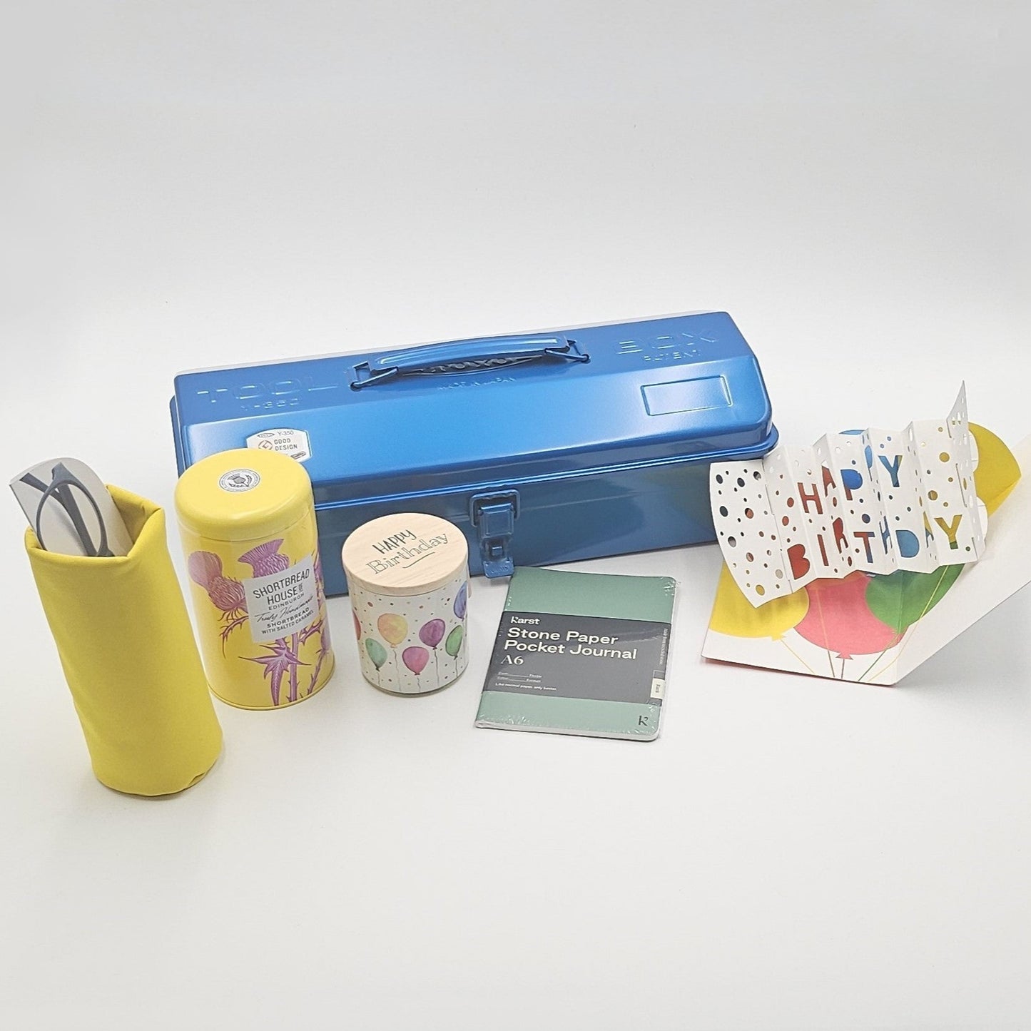 Blaue Geschenkbox mit verschiedenen Produkten im Vordergrund