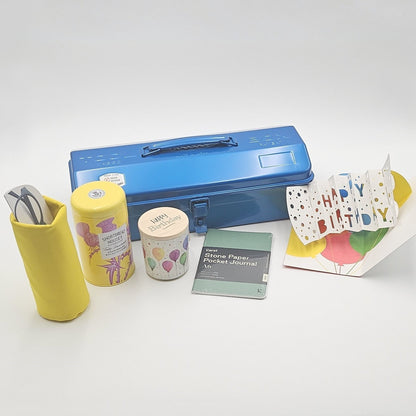Blaue Geschenkbox mit verschiedenen Produkten im Vordergrund