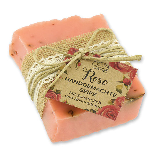 Handgemachte kaltgerührte Schafmilchseife mit Wildrosenduft und Rosenblättern, dekorativ verpackt, ideal für trockene und empfindliche Haut