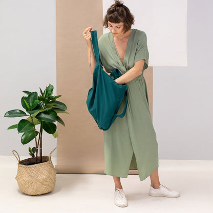 Nachhaltige Notabag in Dunkelgrün, die sich von Tragetasche zu Rucksack verwandeln lässt. Praktisch und stylisch.