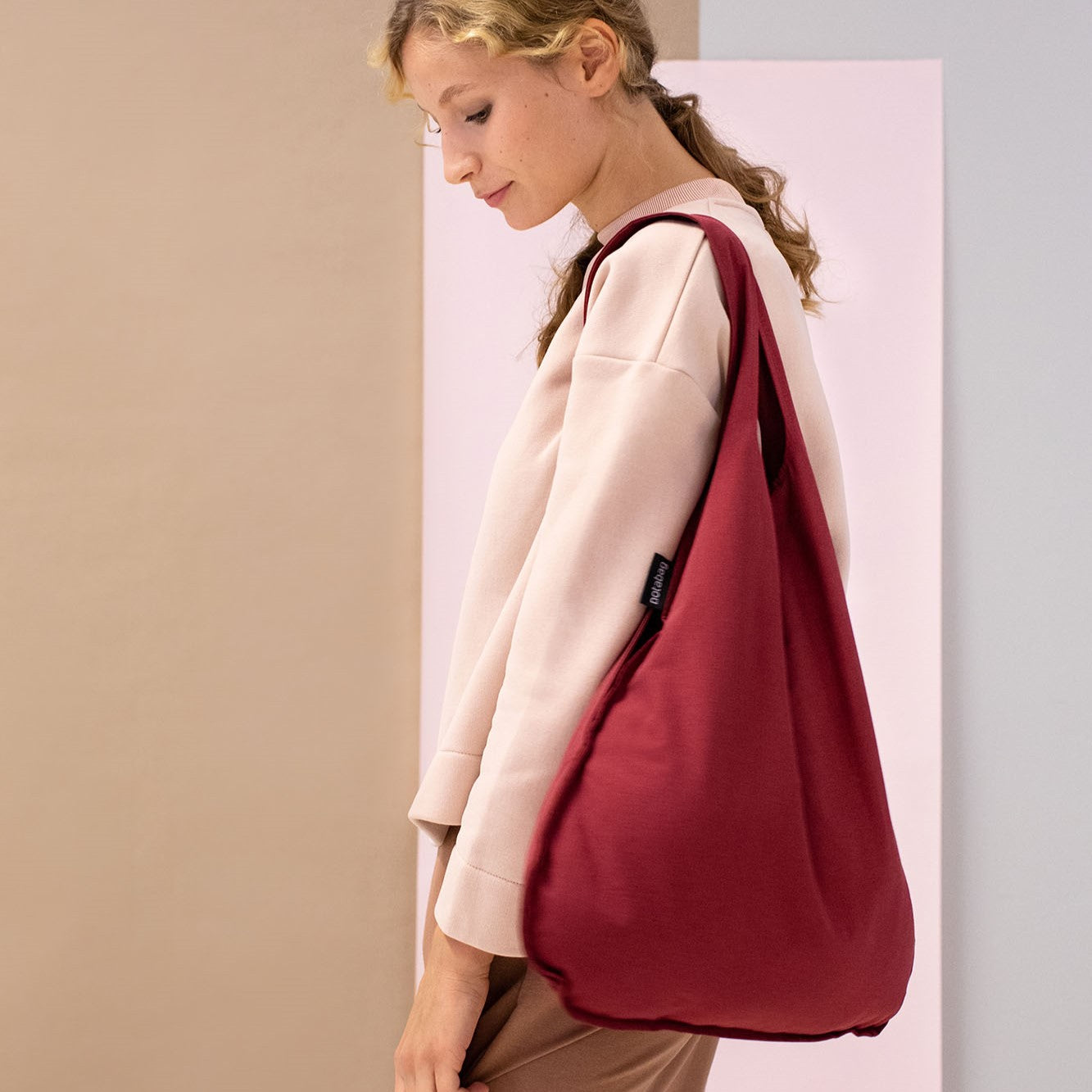 Weinrote Notabag, wandelbar von Tasche zu Rucksack. Nachhaltig, leicht und faltbar – ideal für den Alltag und unterwegs.