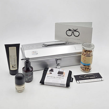 Ride & Recover silberne Geschenkbox, umgeben von den enthaltenen Produkten