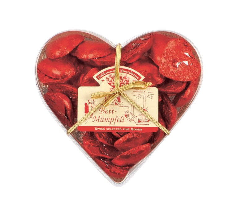 Herzförmige Box gefüllt mit einzeln verpackten, roten Schokoladenherzen aus feiner Schweizer Milchschokolade
