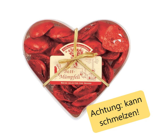 Herzförmige Box gefüllt mit einzeln verpackten, roten Schokoladenherzen aus feiner Schweizer Milchschokolade