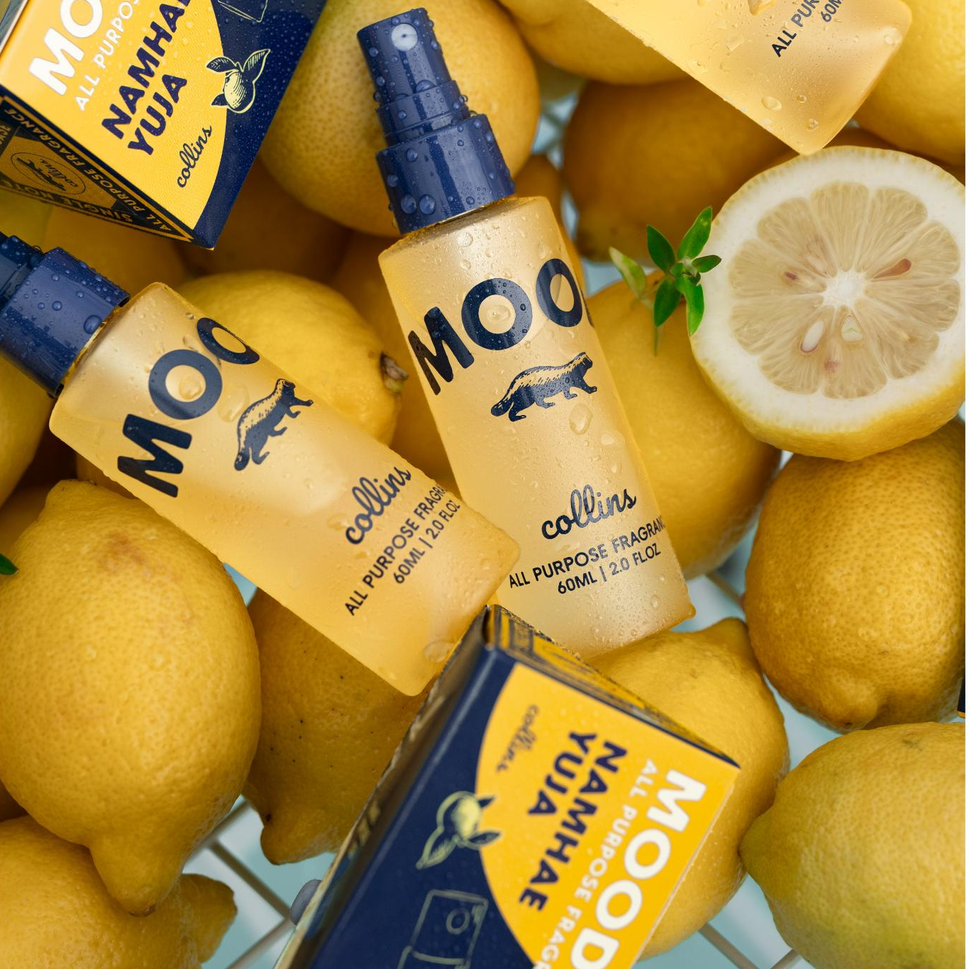 Mood Water mit Zitrusduft Namhae Yuja in Reisegrösse – handliche Flasche mit frischen Zitronen im Hintergrund