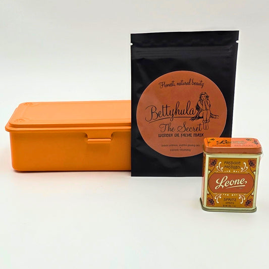 Stilvolle Geschenkbox für sie in Orange mit Schleife, gefüllt mit kleinen Self-care Momenten und süssen Details