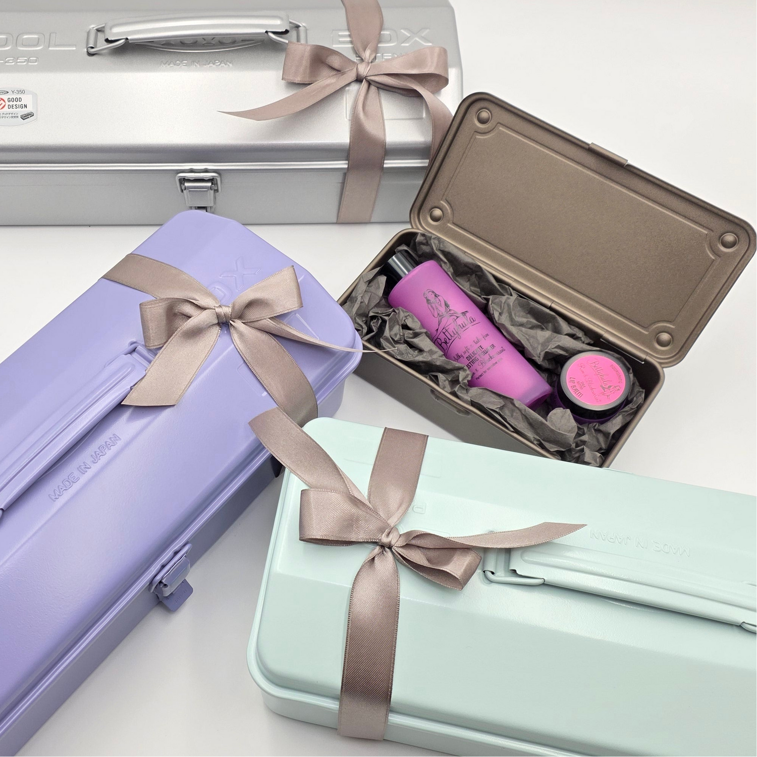 Bunte, versandfertige Geschenke mit elegante Schleifen und eine offene Geschenkbox zeigt den Inhalt