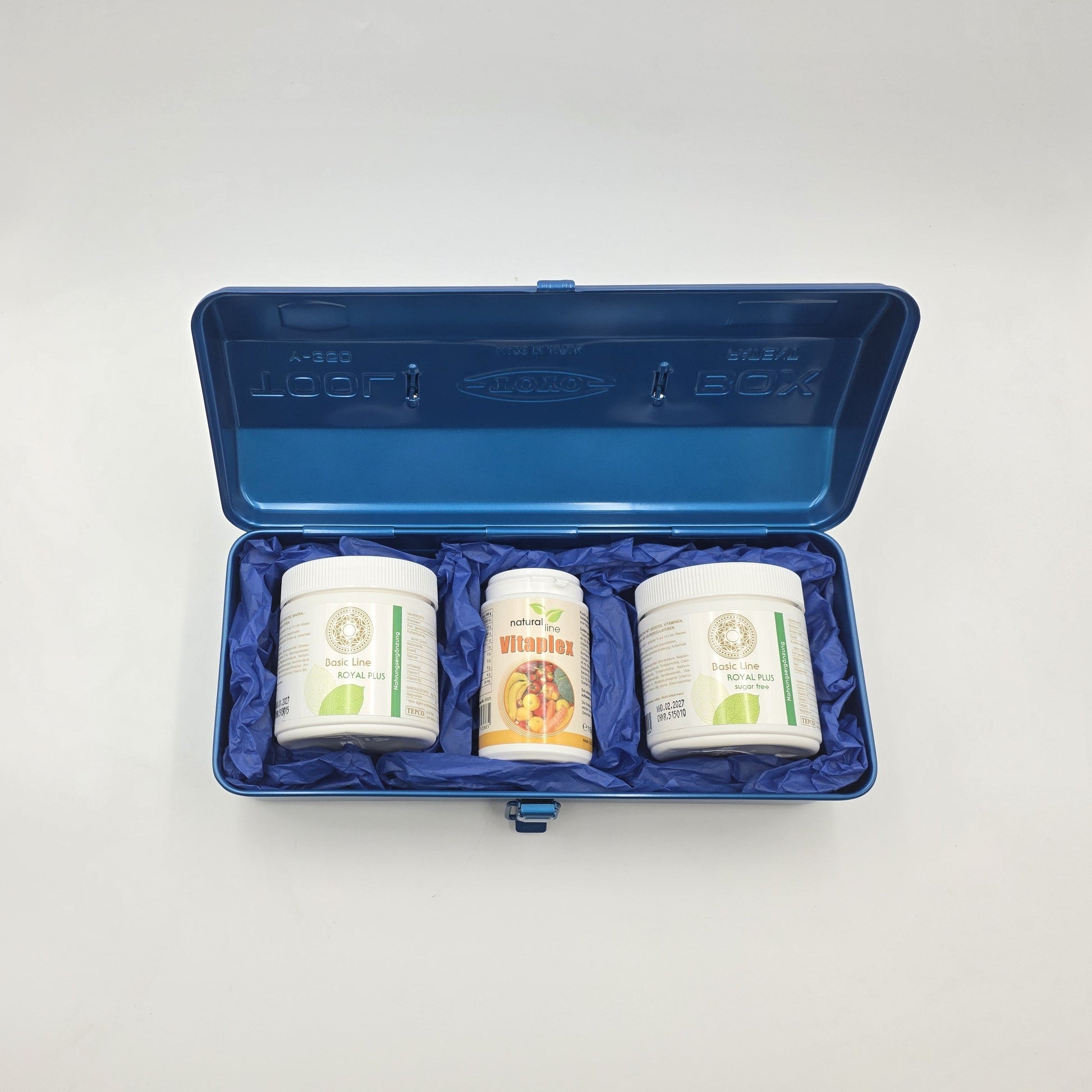Blue Boost Geschenkbox geöffnet mit Royal Plus Basic Pulver, Royal Plus Sugar Free und Vitaplex, stilvoll in einer blauen Aufbewahrungsbox präsentiert